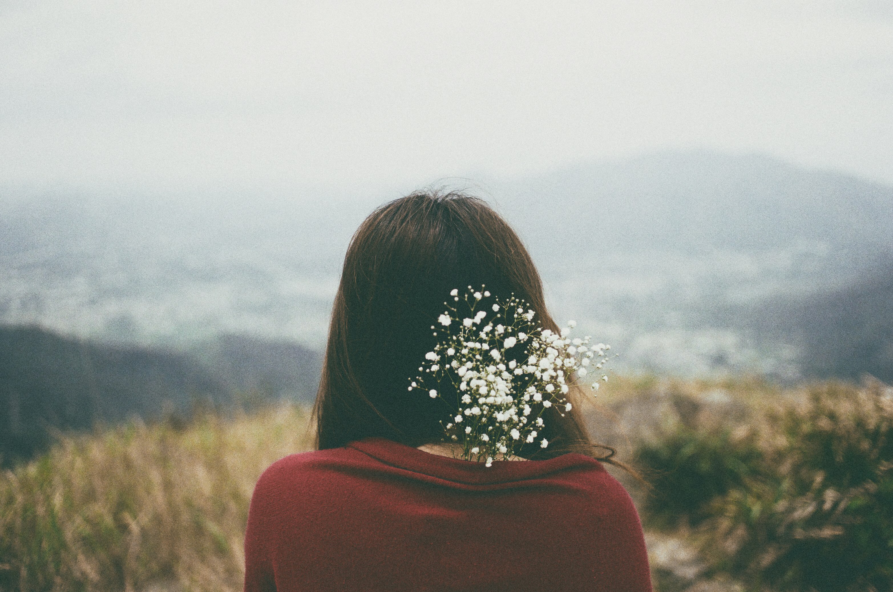 woman wearing red shirt with white flower on back